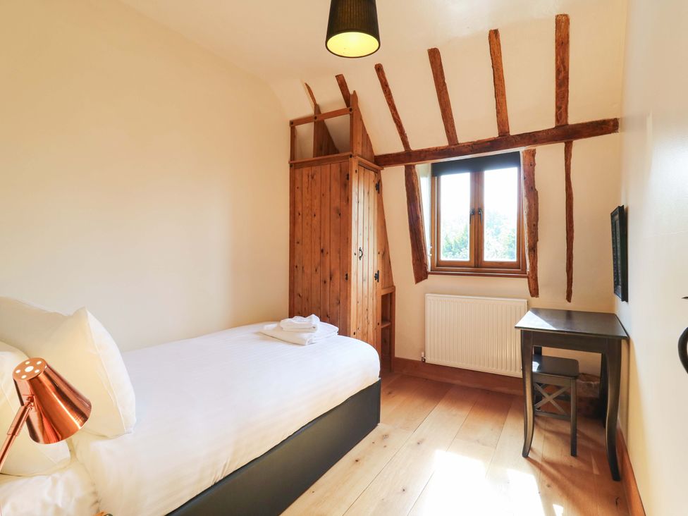 A bedroom with a bed and window at Six Apples in Wethersfield near Finchingfield
