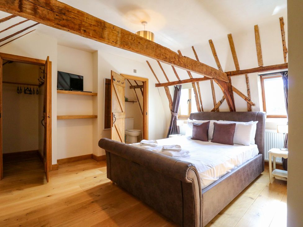 A bedroom with a bed and wardrobe at Six Apples in Wethersfield near Finchingfield