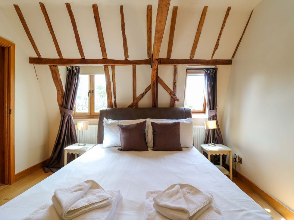 A bedroom with a bed and wooden beams at Six Apples in Wethersfield near Finchingfield