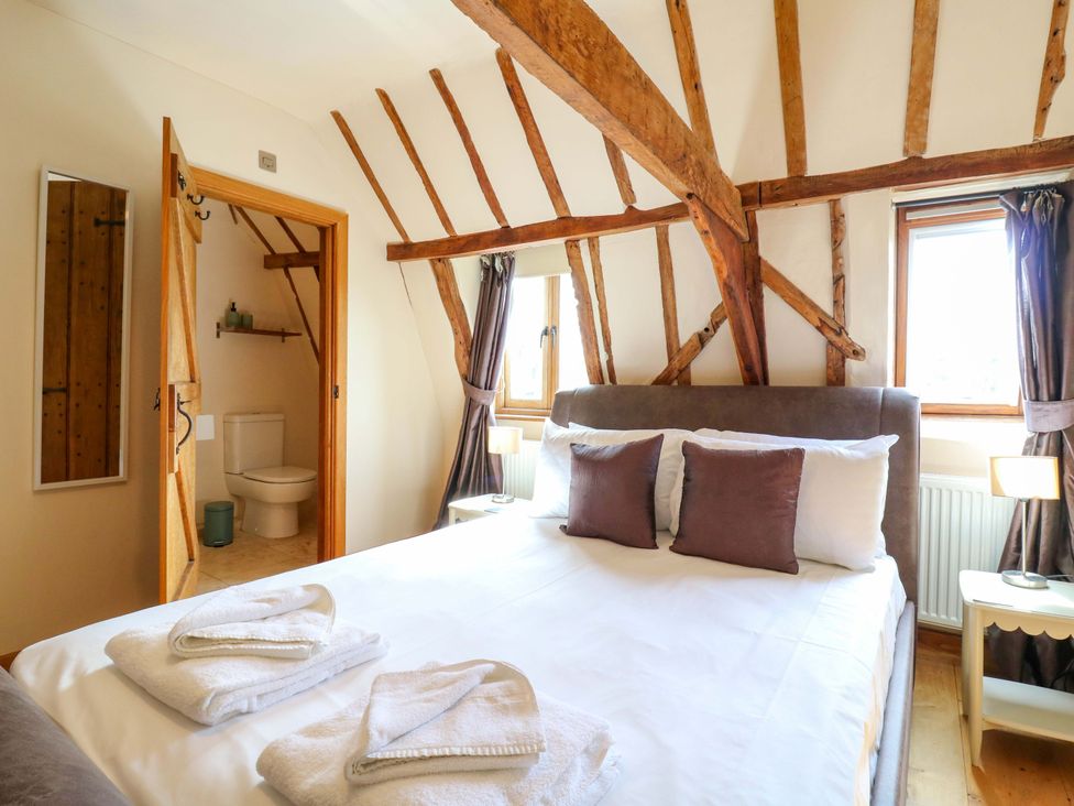 A bedroom with a bed and decorative pillows at Six Apples in Wethersfield near Finchingfield