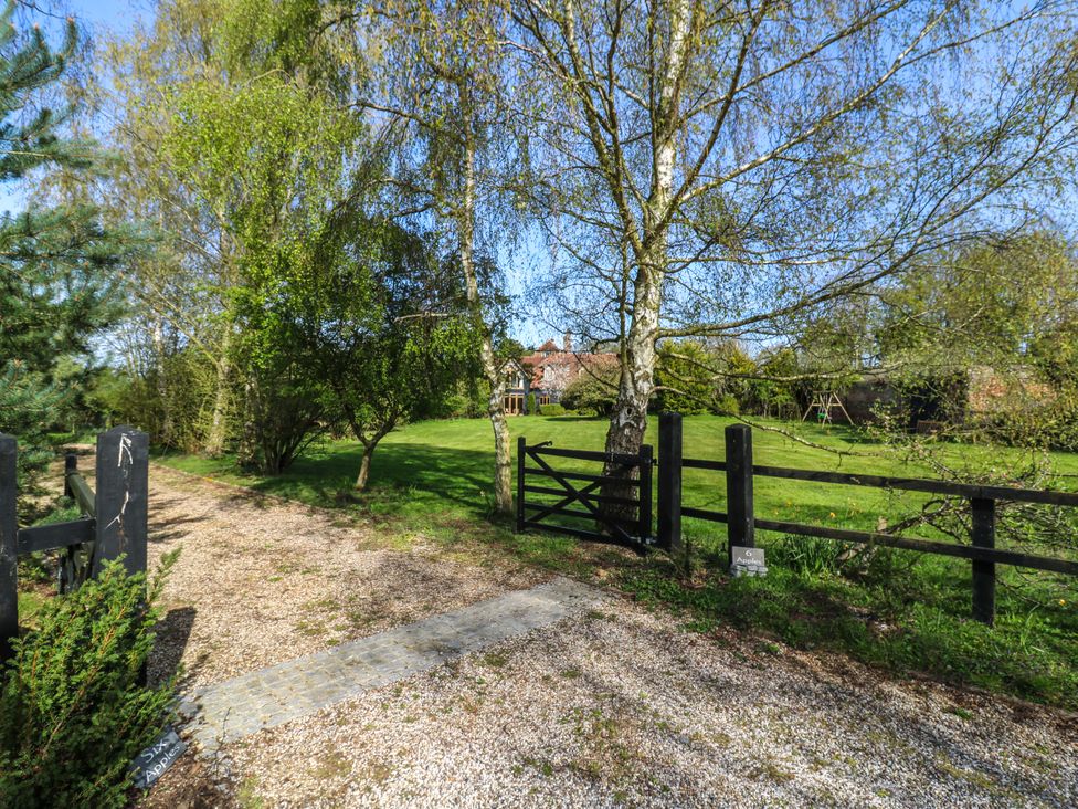 A driveway leading to a house with trees and a gate at Six Apples in Wethersfield near Finchingfield