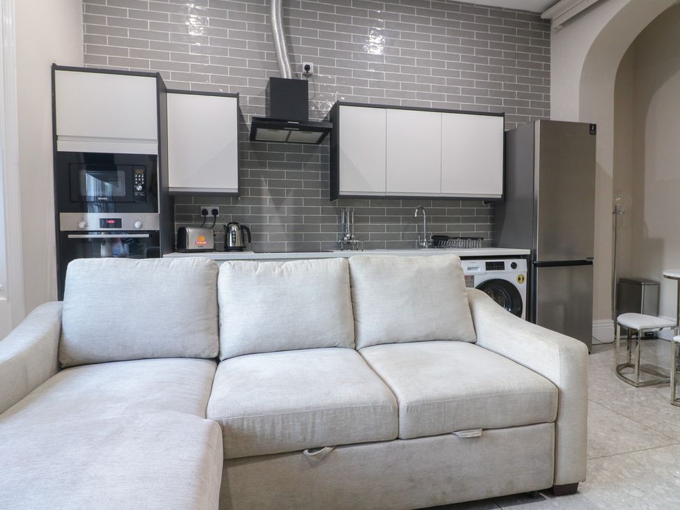 A kitchen with appliances and a sofa at Unit 6 Apt 3 in Sheffield