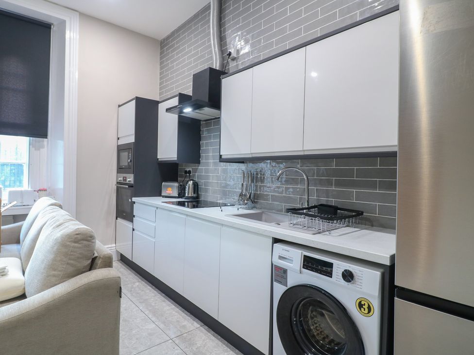 A kitchen with a washing machine and sofa at Unit 6 Apt 3 in Sheffield