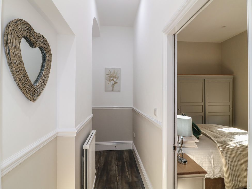 A hallway with a mirror and wall art leading to a bedroom at Unit 6 Apt 3 Sheffield