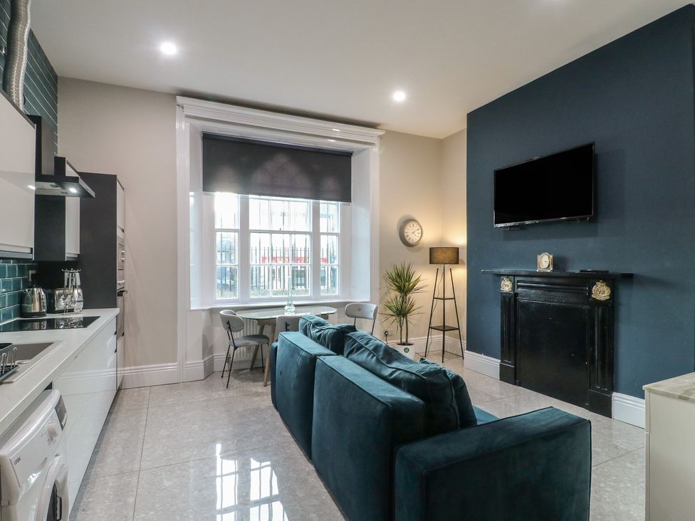 A living room with a kitchen area and a TV at Unit 6 Apt 1 in Sheffield