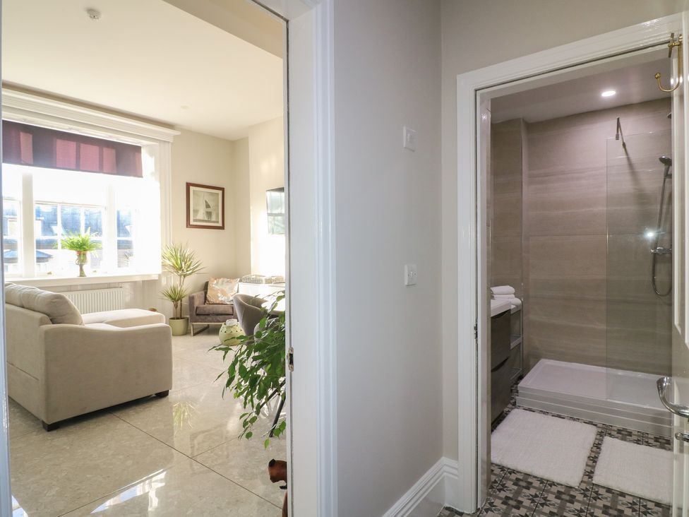 A bathroom with a shower and a living room with seating at Unit 7 Apt 2 Sheffield