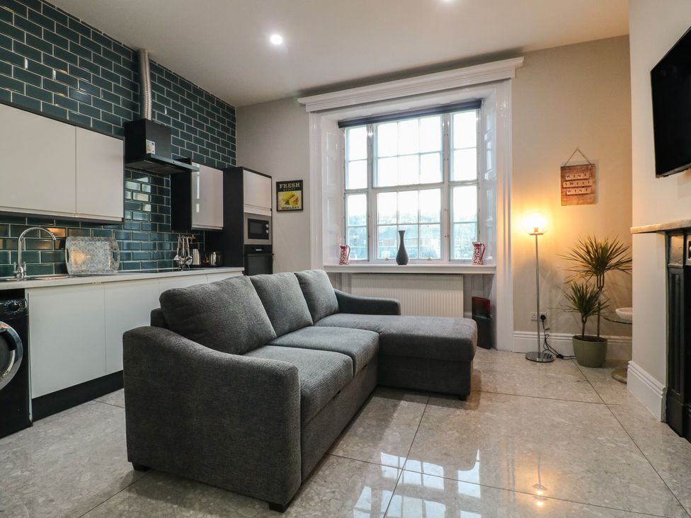 A living room with a sofa and kitchen appliances at Unit 7 Apt 3 in Sheffield