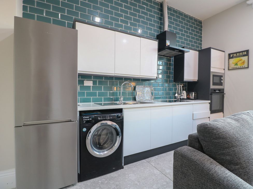 A kitchen with appliances including a refrigerator and washing machine at Unit 7 Apt 3 in Sheffield