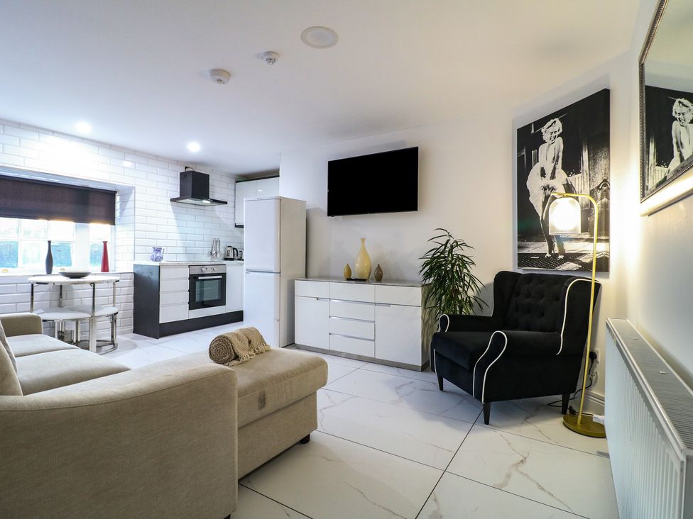 A living room with a sofa and kitchen area at Unit 7 Apt 4 in Sheffield