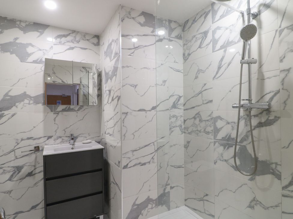 A bathroom with a shower, sink, and mirror at Unit 7 Apt 4 in Sheffield