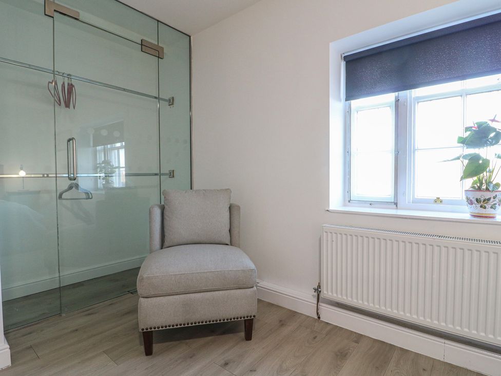 A bedroom with an armchair and sliding glass door at Unit 7 Apt 6 (Delux) Sheffield