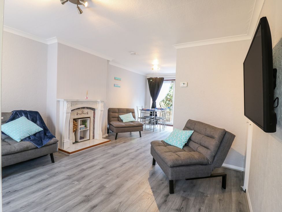 A living room with a fireplace and television at Sea Rose Cottage