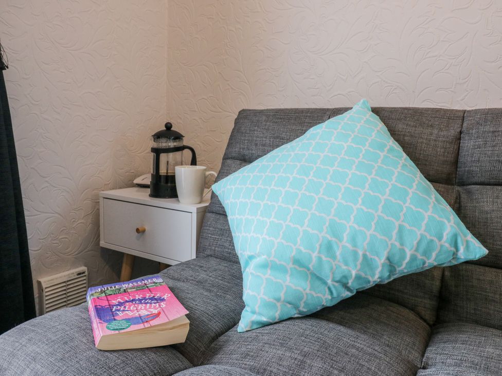 A living room with a couch and a coffee table at Sea Rose Cottage