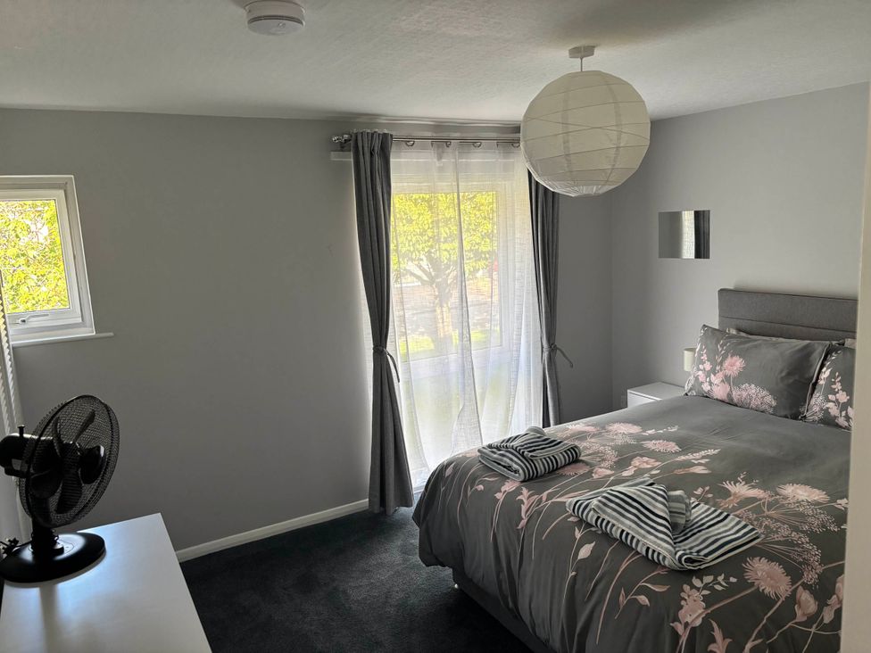 A bedroom with a bed, fan and window at Sea Rose Broadstairs in Broadstairs