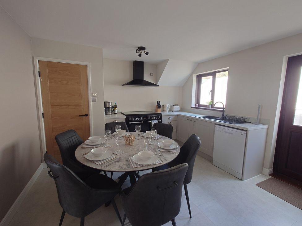 A kitchen with a dining table and chairs at Upper Longlands in Dawlish