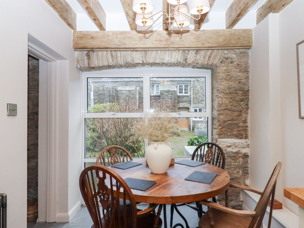 A dining room with a round table and chairs at Garden Cottage at the Bowden Estate Stoke Fleming