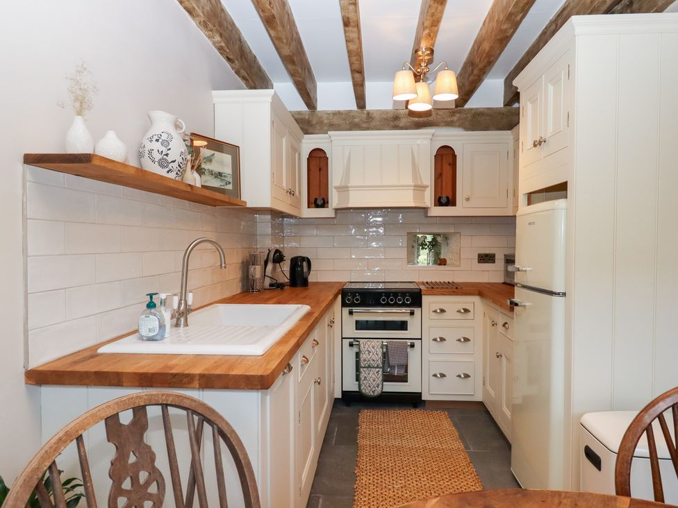 A kitchen with cabinets and a stove at Garden Cottage at the Bowden Estate Stoke Fleming