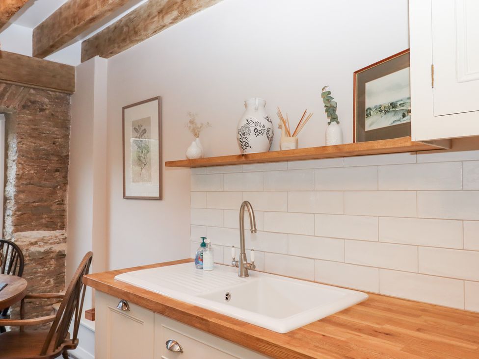A kitchen with a sink and wooden countertop at Garden Cottage at the Bowden Estate Stoke Fleming