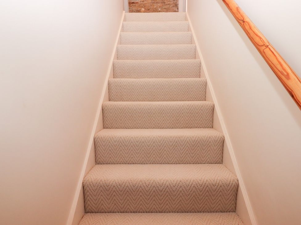 Staircase with carpet and a handrail at Garden Cottage at the Bowden Estate Stoke Fleming