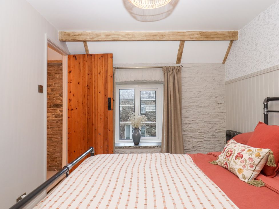 A bedroom with a bed and window at Garden Cottage at the Bowden Estate Stoke Fleming