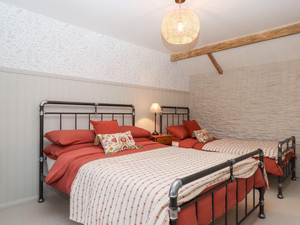 A bedroom with two beds and a lamp at Garden Cottage at the Bowden Estate Stoke Fleming