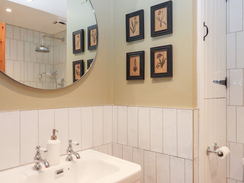 A bathroom with a sink and mirror at Garden Cottage at the Bowden Estate Stoke Fleming