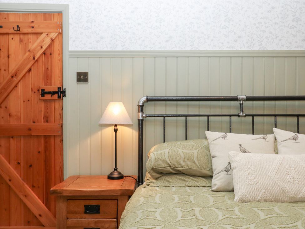 A bedroom with a bed and bedside table at Garden Cottage at the Bowden Estate Stoke Fleming