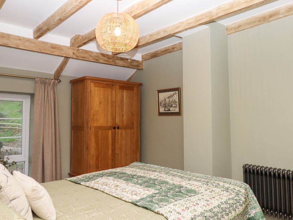 A bedroom with a bed and wardrobe at Garden Cottage at the Bowden Estate Stoke Fleming