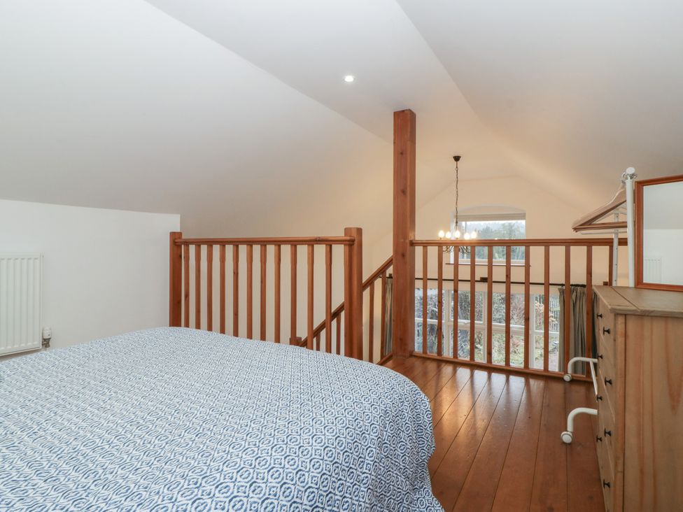 A bedroom with a bed and chest of drawers at Horse Gin, Lydney