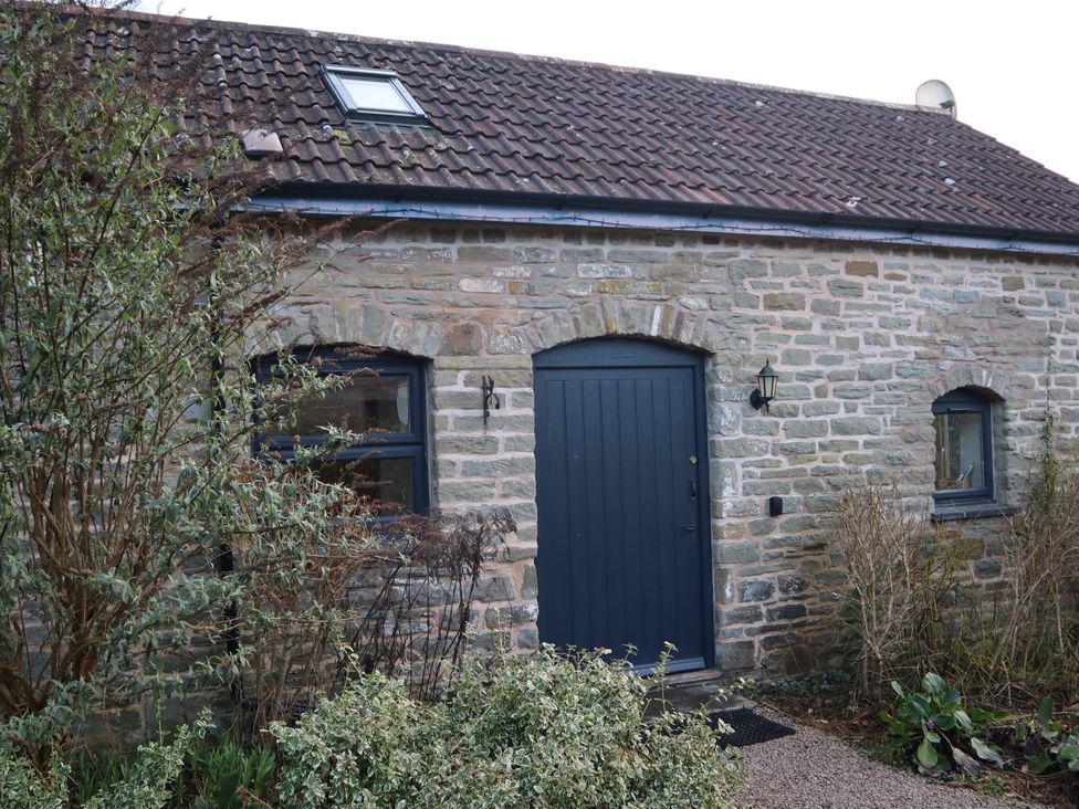 An exterior view of a stone cottage with a blue door at Horse Gin in Parkend
