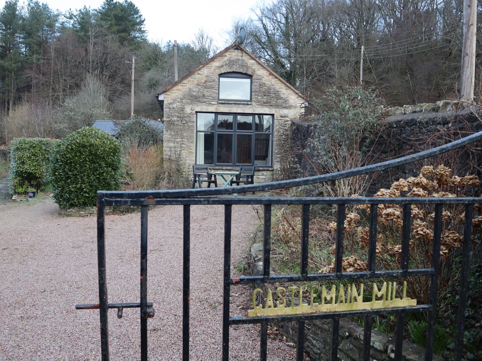 An outdoor view of a house with a garden at Castlemain Mill in Parkend