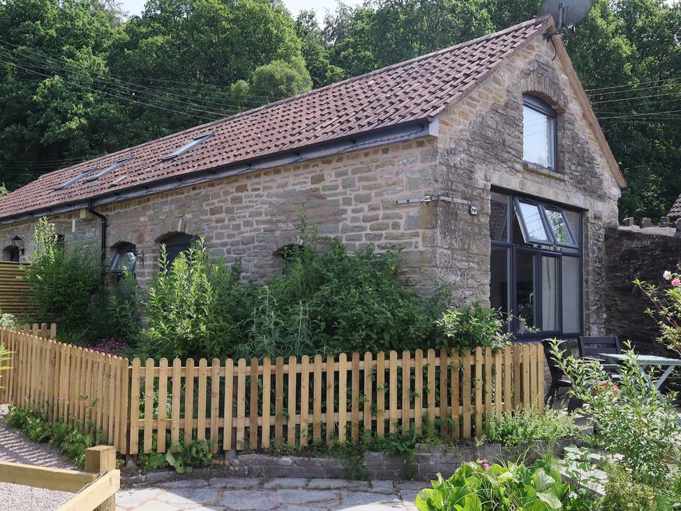 An outdoor view of a stone building with a fence at Horse Gin in Parkend