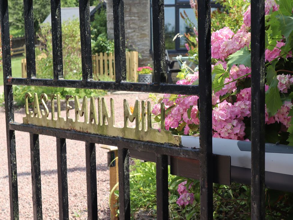 A garden gate with flowers and a path at Horse Gin in Parkend