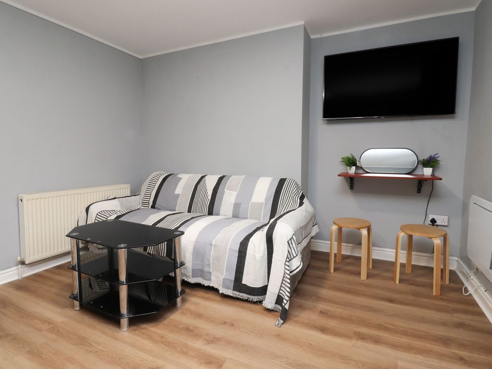 A living room with a sofa and TV at 38B Yorkshire Street Morecambe