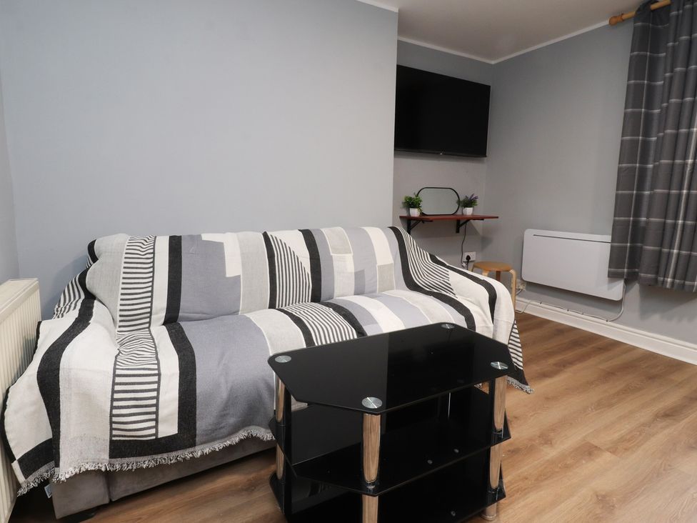 A living room with a sofa and TV at 38B Yorkshire Street Morecambe