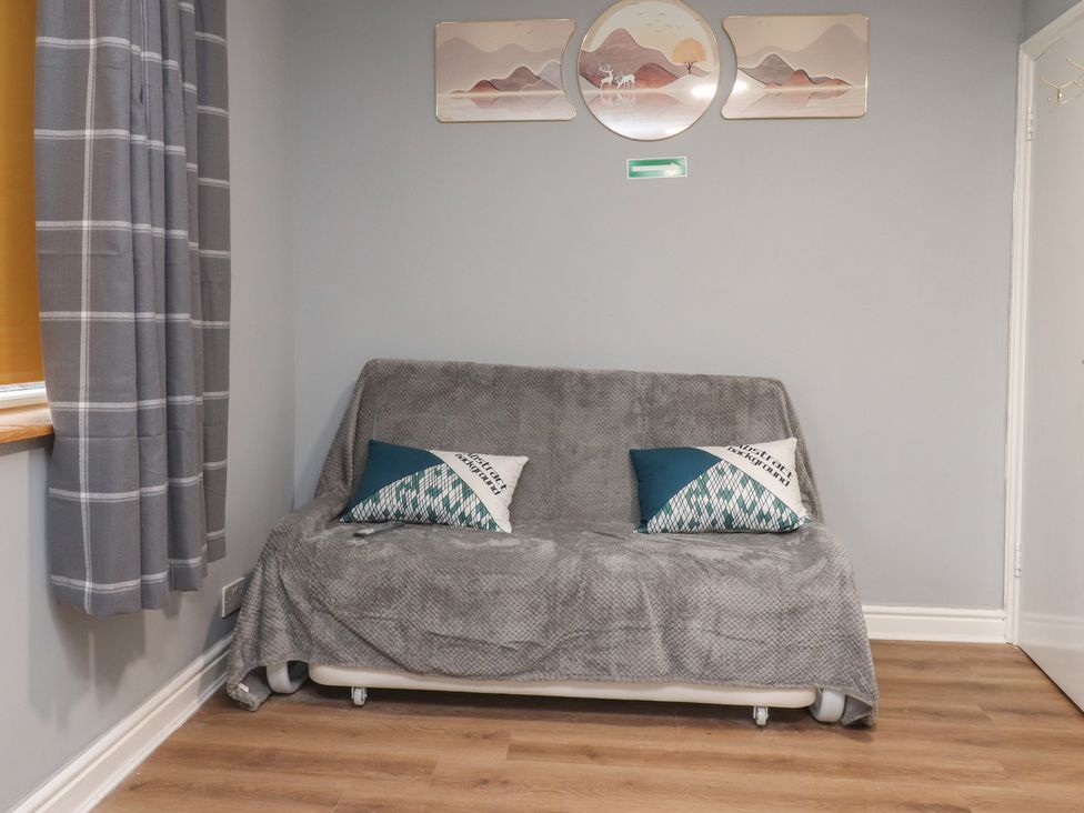 A living room with a sofa and wall art at 38B Yorkshire Street Morecambe