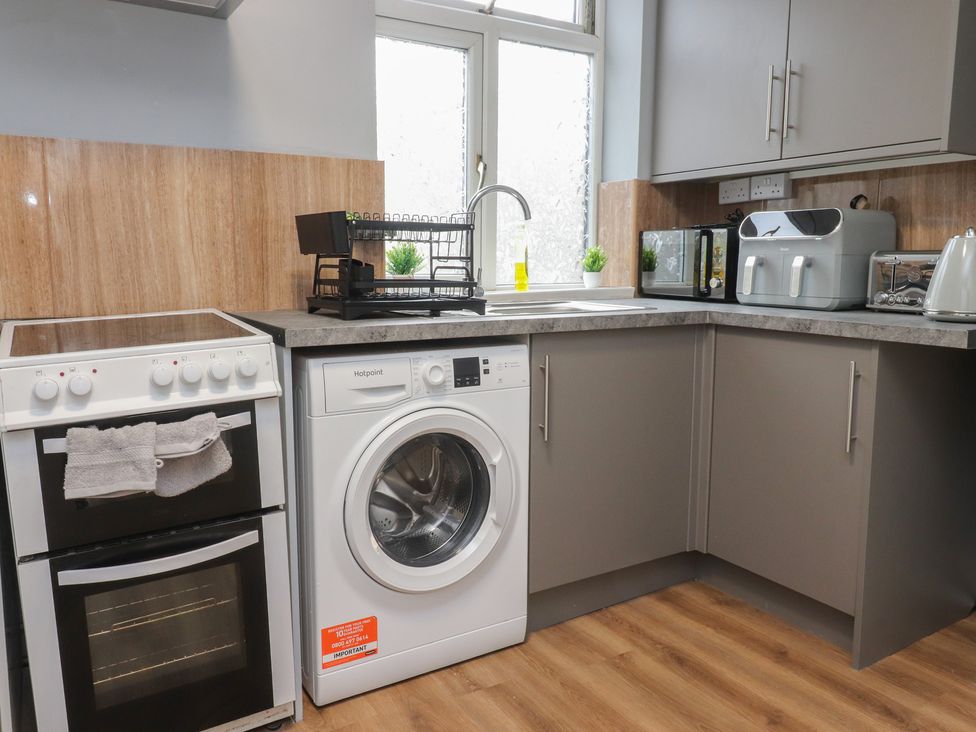 A kitchen with a washing machine and oven at 38B Yorkshire Street Morecambe