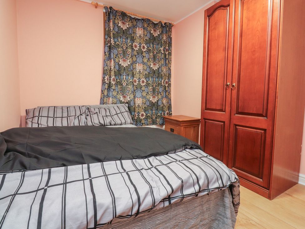 A bedroom with a bed and wardrobe at 38B Yorkshire Street in Morecambe