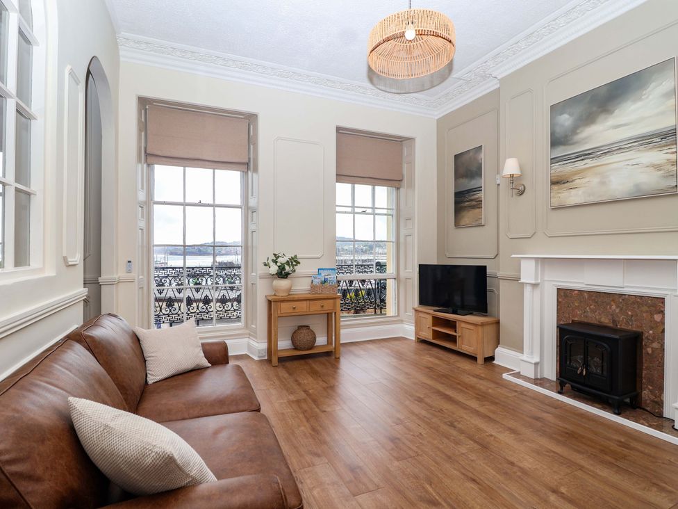 A living room with a sofa and television at Flat 2 The Moorings Torquay