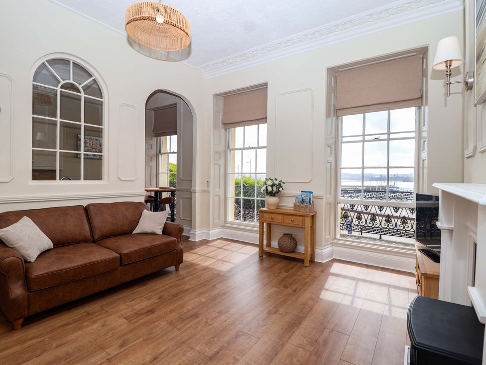 A living room with windows and a sofa at Flat 2 The Moorings in Torquay