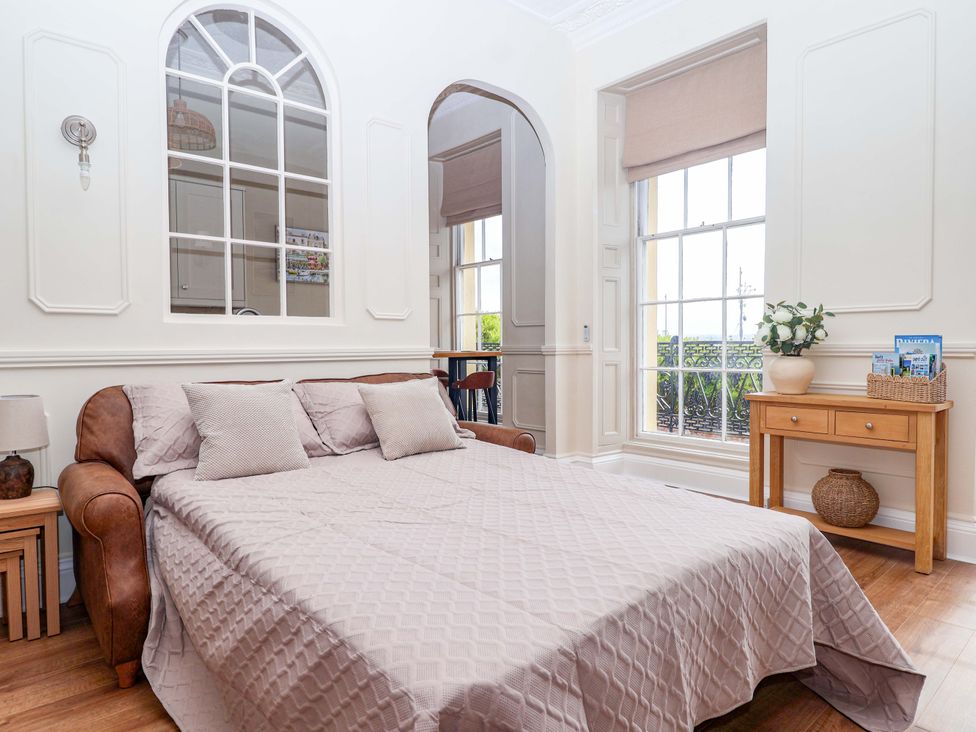 A bedroom with a bed and a side table at Flat 2 The Moorings in Torquay