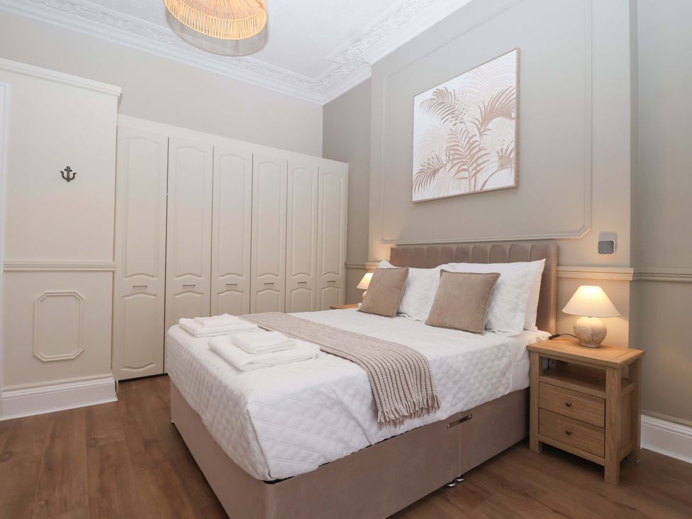 A bedroom with a bed and wardrobe at Flat 2 The Moorings in Torquay