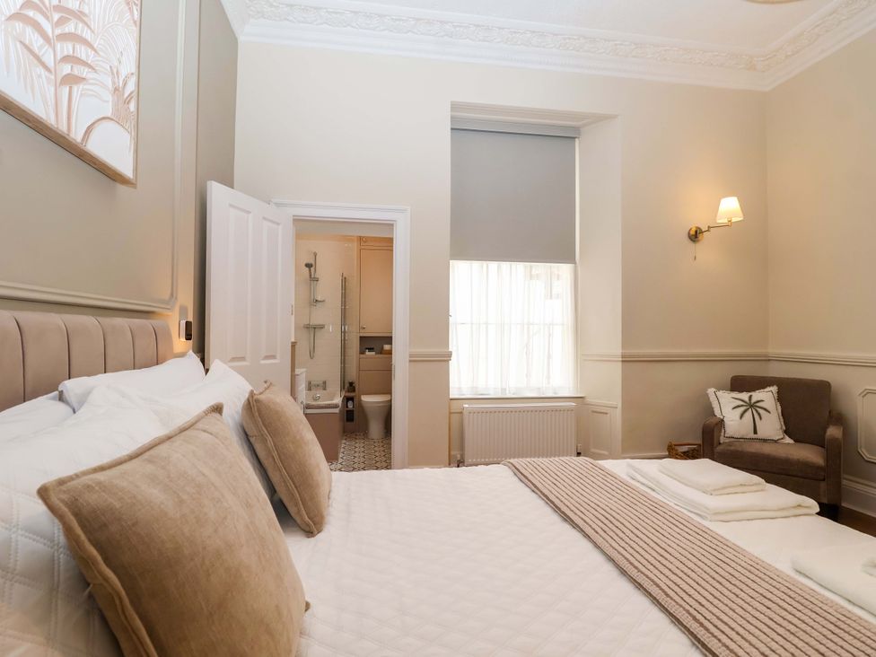 A bedroom with a bed and a chair at Flat 2 The Moorings in Torquay