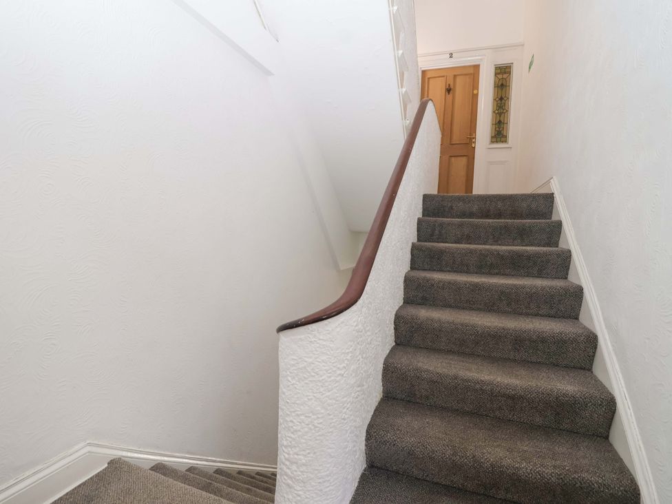 A staircase leading to a door in a hallway at Flat 2 The Moorings Torquay