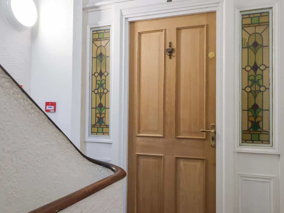 A wooden door with stained glass windows in a hallway at Flat 2 The Moorings Torquay