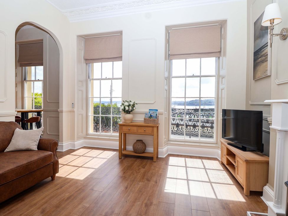 A living room with a sofa and television at Flat 2 The Moorings in Torquay