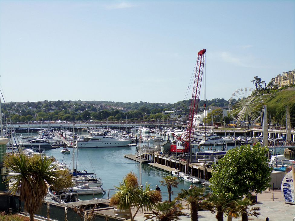 A harbor with boats and a crane at Flat 2 The Moorings in Torquay