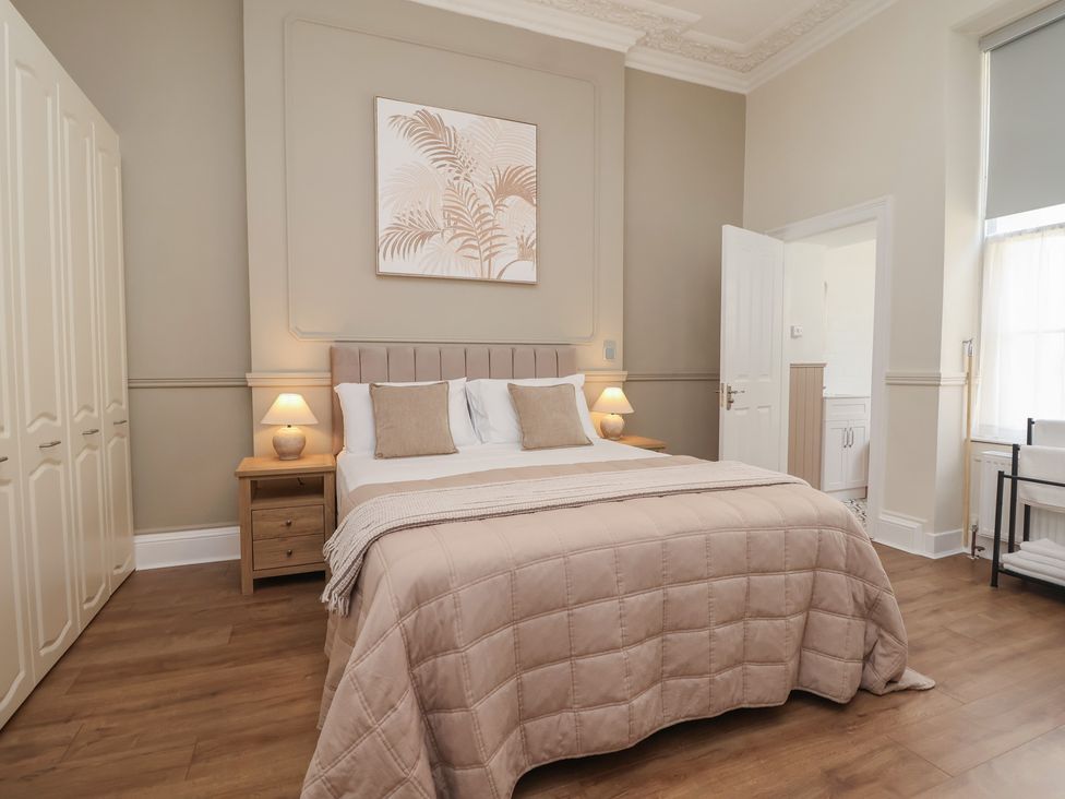 A bedroom with a bed and wardrobe at Flat 2 The Moorings in Torquay