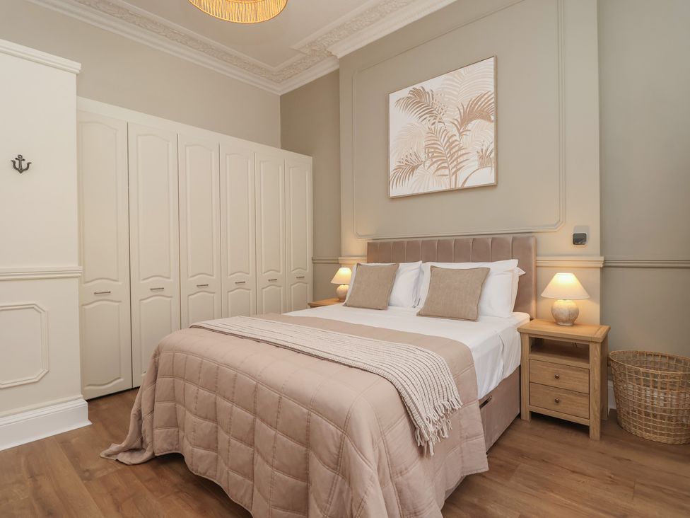 A bedroom with a bed and wardrobe at Flat 2 The Moorings in Torquay