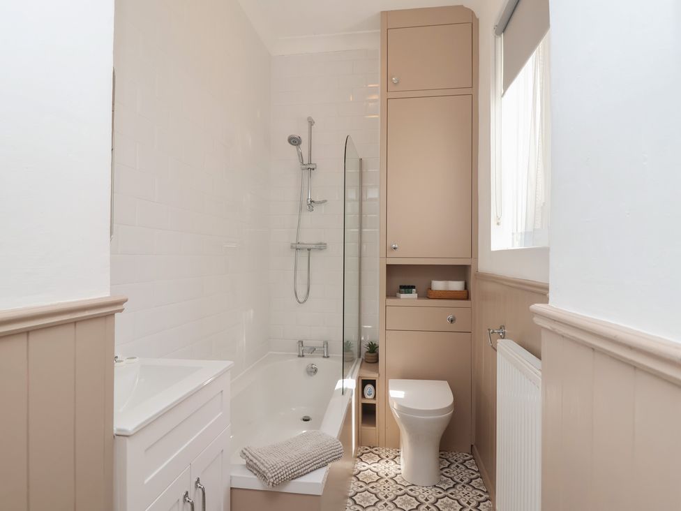 A bathroom with a bathtub, sink, and toilet at Flat 2 The Moorings Torquay